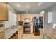 Bright kitchen features an island, granite countertops, tile flooring, and modern appliances at 2308 Avery Dr, Las Vegas, NV 89108