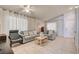 Bright living room with neutral tile floors, ample seating, and natural light from sheer curtains at 2308 Avery Dr, Las Vegas, NV 89108