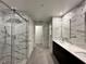 Modern bathroom with marble walls, glass shower, and double vanity sinks at 2685 Conifer Canyon St, Henderson, NV 89044