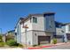 Modern two-story townhome with blue and white exterior, featuring an attached garage and manicured landscaping at 2685 Conifer Canyon St, Henderson, NV 89044