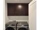 Laundry room featuring a front-load washer and dryer with dark cabinets above at 2685 Conifer Canyon St, Henderson, NV 89044