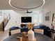 Open-concept living space with large sectional sofa, modern lighting, and staircase at 2685 Conifer Canyon St, Henderson, NV 89044