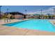 Community pool area with lounge chairs and covered structure for shade on a sunny day at 2685 Conifer Canyon St, Henderson, NV 89044