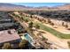 An aerial view of the community golf course with a home, pool, and spa in the foreground at 30 Meadowhawk Ln, Las Vegas, NV 89135