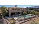 Back exterior aerial view featuring a large covered outdoor seating area, inground pool, spa, and custom fire pit at 30 Meadowhawk Ln, Las Vegas, NV 89135