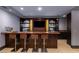 Home bar with wooden counter, sink, and shelving, as well as four barstools, and decorative backsplash at 30 Meadowhawk Ln, Las Vegas, NV 89135