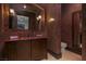 Bathroom with a red marble countertop, mosaic backsplash, and a decorative mirror at 30 Meadowhawk Ln, Las Vegas, NV 89135