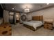 Bedroom with a wooden bed frame, modern chandelier, decorative art piece, and ensuite bath at 30 Meadowhawk Ln, Las Vegas, NV 89135