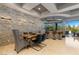 Modern dining area with a unique stone accent wall, stylish lighting, and convenient access to an outdoor patio at 30 Meadowhawk Ln, Las Vegas, NV 89135