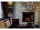 Close-up of a stone fireplace with modern metal art and plush velvet seating at 30 Meadowhawk Ln, Las Vegas, NV 89135