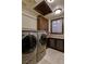 Well-lit laundry room with front-load washer and dryer, granite countertops, and custom cabinets at 30 Meadowhawk Ln, Las Vegas, NV 89135