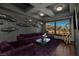 Stylish living room with plush purple seating, unique decor, and a picturesque view of the surrounding landscape at 30 Meadowhawk Ln, Las Vegas, NV 89135