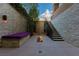 Private patio with stone walls, bench seating, stairs to upper level, and a fire pit at 30 Meadowhawk Ln, Las Vegas, NV 89135