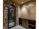 An arched stone doorway with a wrought iron gate leading to the wine cellar with custom wood cabinets at 30 Meadowhawk Ln, Las Vegas, NV 89135