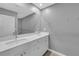 Well-lit bathroom featuring dual sinks with white cabinets and a large mirror at 3192 Timorasso Ave, Henderson, NV 89044