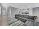 Spacious open-concept with neutral walls, tile flooring, gray sectional sofa, and modern accents at 3192 Timorasso Ave, Henderson, NV 89044