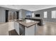 Open living space with a kitchen island, stainless steel dishwasher and a comfortable gray sofa at 3192 Timorasso Ave, Henderson, NV 89044