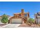 Inviting two-story home with a classic design, featuring a two-car garage and beautiful desert landscaping at 361 Tobler Dr, Las Vegas, NV 89145