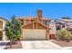 Attractive home featuring a well-manicured lawn, attached garage, and charming architectural details at 361 Tobler Dr, Las Vegas, NV 89145