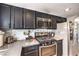 Kitchen featuring dark cabinets, stainless steel appliances, ample counter space, and modern mosaic backsplash at 361 Tobler Dr, Las Vegas, NV 89145