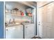 Functional laundry room with washer, dryer, shelving, and a white door at 361 Tobler Dr, Las Vegas, NV 89145