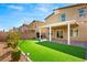 Expansive backyard features artificial grass, covered patio, and mature landscaping at 382 Scarlet Pine Ct, Henderson, NV 89044