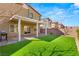 Lush backyard with artificial turf, covered patio, and well-manicured landscaping at 382 Scarlet Pine Ct, Henderson, NV 89044