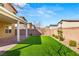 Grassy backyard with a covered patio, low maintenance landscaping, and privacy fence at 382 Scarlet Pine Ct, Henderson, NV 89044