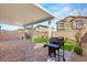 Inviting backyard patio with brick pavers, covered area, grill, and artificial grass at 382 Scarlet Pine Ct, Henderson, NV 89044
