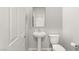 Small bathroom with a pedestal sink and toilet at 382 Scarlet Pine Ct, Henderson, NV 89044