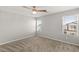 Spacious bedroom with neutral carpet, bright windows, and a modern ceiling fan at 382 Scarlet Pine Ct, Henderson, NV 89044
