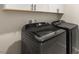 Modern laundry room with front loading washer and dryer and white cabinetry at 382 Scarlet Pine Ct, Henderson, NV 89044