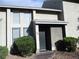 Two-story townhouse with neutral stucco, mature shrubbery, and covered front entry with security door at 432 Sellers Pl, Henderson, NV 89011