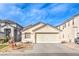Beige single-story home with a two-car garage and simple landscaping, nestled in a residential neighborhood at 4381 Coyote Crest Ct, Las Vegas, NV 89147