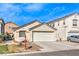Beige single-story home with a two-car garage and minimal landscaping, under a bright blue sky at 4381 Coyote Crest Ct, Las Vegas, NV 89147