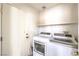 Bright laundry room with washer, dryer and storage shelf at 4381 Coyote Crest Ct, Las Vegas, NV 89147