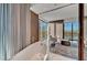 A soaking tub sits beside windows with curtains that overlook city views and mountains beyond at 4381 W Flamingo Rd # 9301, Las Vegas, NV 89103