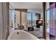 A soaking tub sits beside windows that overlook a balcony and a city view with mountains at 4381 W Flamingo Rd # 9301, Las Vegas, NV 89103