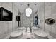 A luxurious bathroom with marble walls, dual sinks, modern lighting, and glass enclosed shower at 4381 W Flamingo Rd # 9301, Las Vegas, NV 89103
