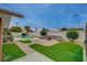 Private backyard oasis featuring a pool, mature landscaping, and a built-in fire pit with seating at 4678 San Benito St, Las Vegas, NV 89121