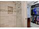 Tiled shower with glass doors and built-in shelves for added convenience at 4678 San Benito St, Las Vegas, NV 89121