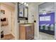 Bathroom with glass-enclosed shower, dark vanity, and a view to the primary bedroom at 4678 San Benito St, Las Vegas, NV 89121