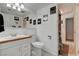 Cozy bathroom featuring wood trim vanity, white fixtures, framed art, and tile flooring at 4678 San Benito St, Las Vegas, NV 89121
