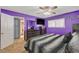 The bright bedroom has purple walls, wood-look ceiling fan, and a dresser with mirror at 4678 San Benito St, Las Vegas, NV 89121