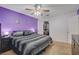 This bedroom features purple accent walls, a ceiling fan, and an open closet with plenty of storage at 4678 San Benito St, Las Vegas, NV 89121