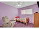 Purple bedroom with a ceiling fan and a recliner chair at 4678 San Benito St, Las Vegas, NV 89121