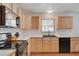 Well-lit kitchen features light wood cabinets, black appliances, and a window over the sink at 4678 San Benito St, Las Vegas, NV 89121