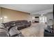 Living room showcasing a large leather sofa, carpeted floors, and access to the backyard at 4678 San Benito St, Las Vegas, NV 89121