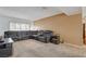 Cozy living room featuring a large leather sofa, neutral walls, and carpeted flooring at 4678 San Benito St, Las Vegas, NV 89121