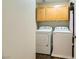 A well-equipped laundry room with a washer, dryer, and overhead cabinets for storage and organization at 5024 Stone Bay Ave, Las Vegas, NV 89131
